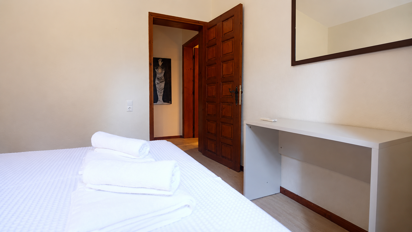 Bright guest bedroom with traditional wooden door