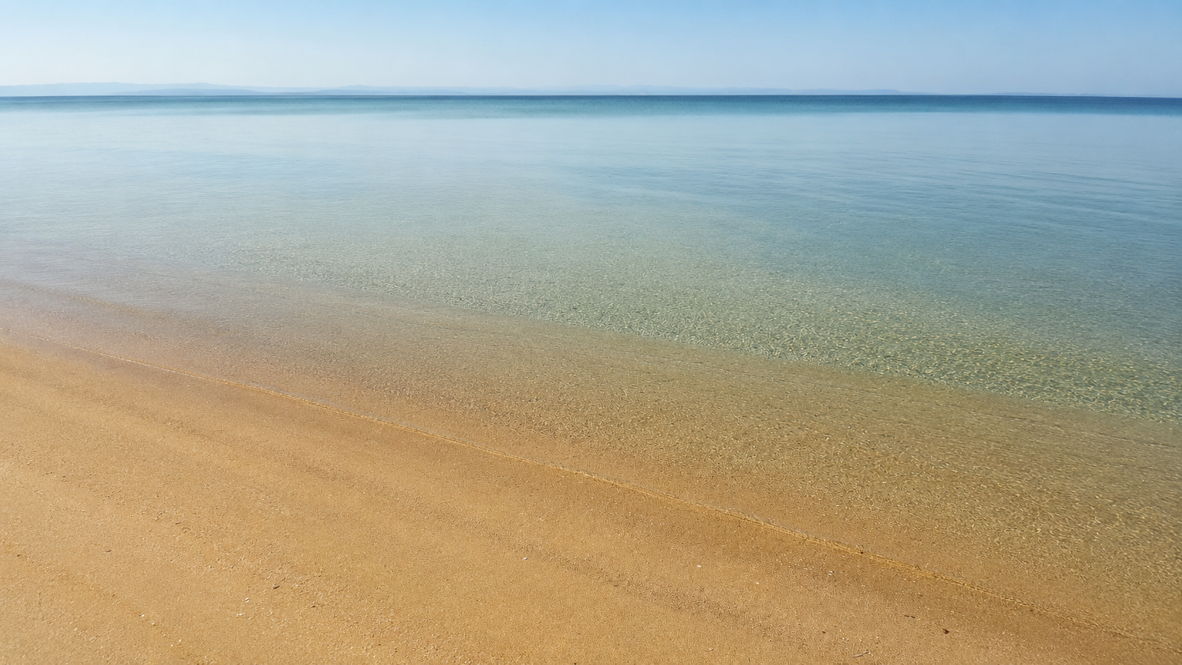 Clear shallow water on the sandy shore