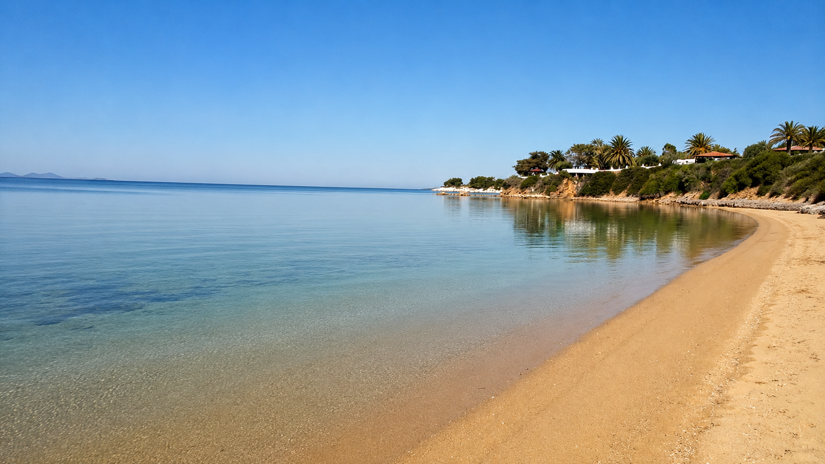 The calm sandy bay beside the property